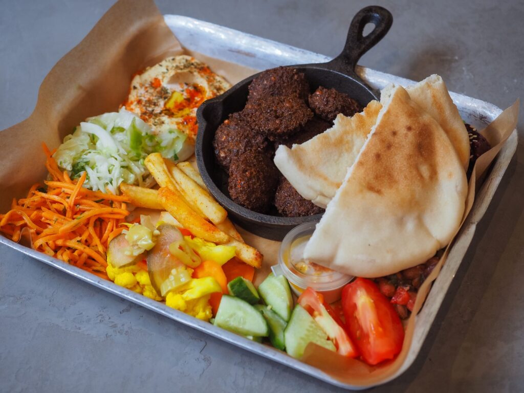 Delicious Mediterranean platter with falafel, pita bread, and fresh veggies.