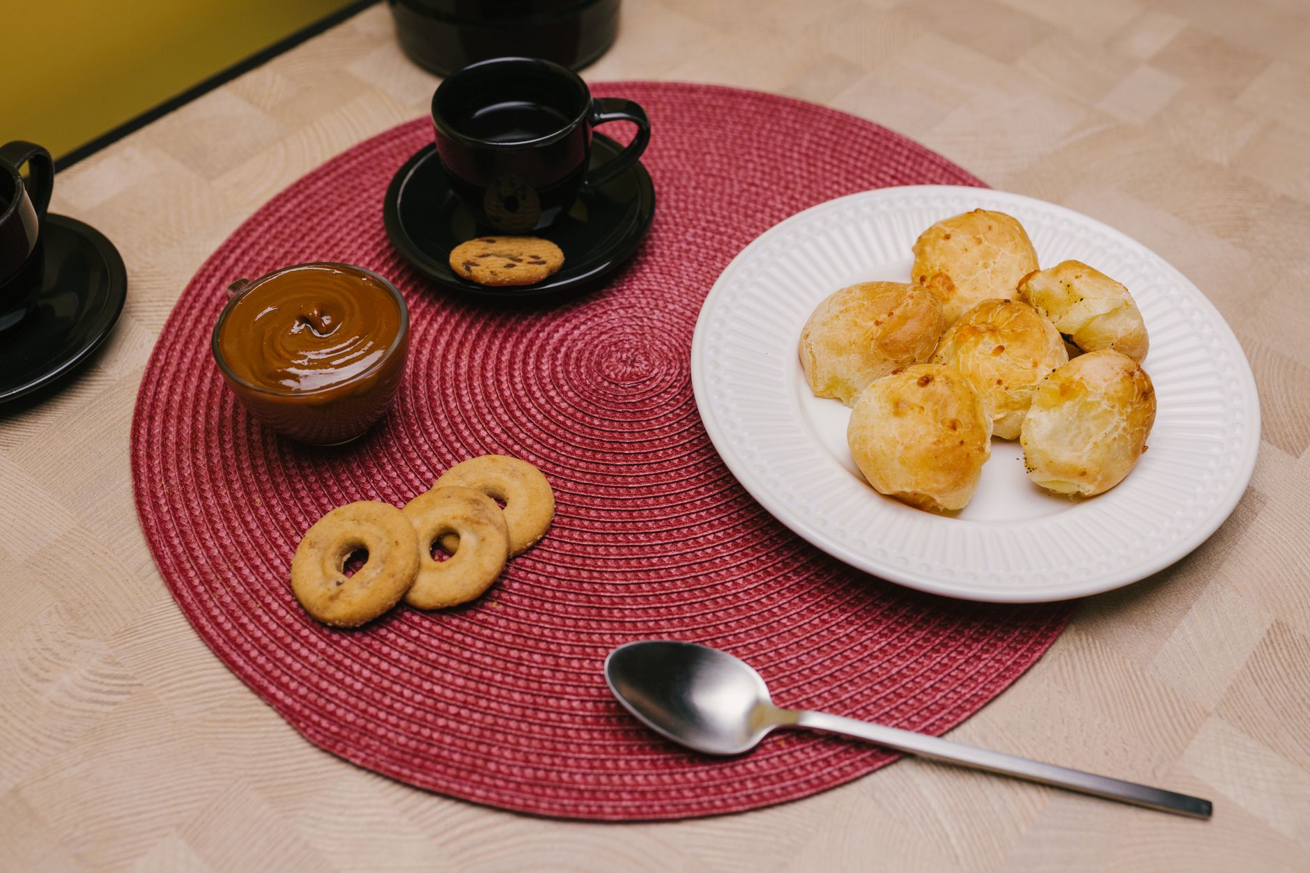 Delicious Brazilian snacks including pão de queijo, coffee, and cookies on a table.