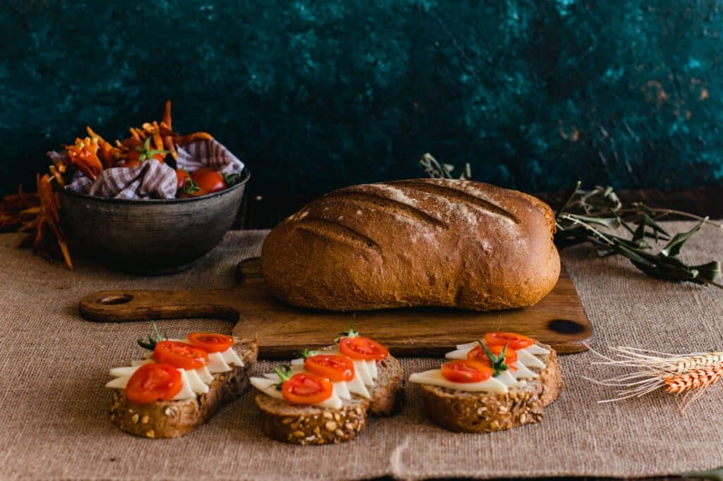 Fresh multi-grain bread with cheese and tomato slices on rustic board in Istanbul.